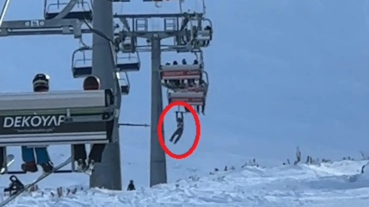 Düşen snowboardını almak için atlamaya çalıştığı telesiyejde asılı kaldı