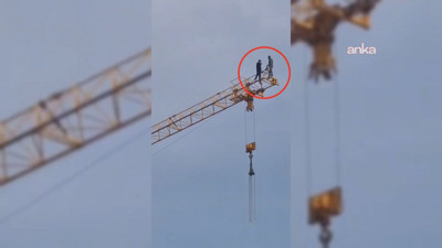 Maaşlarını alamayan inşaat işçileri vincin üzerine çıktı